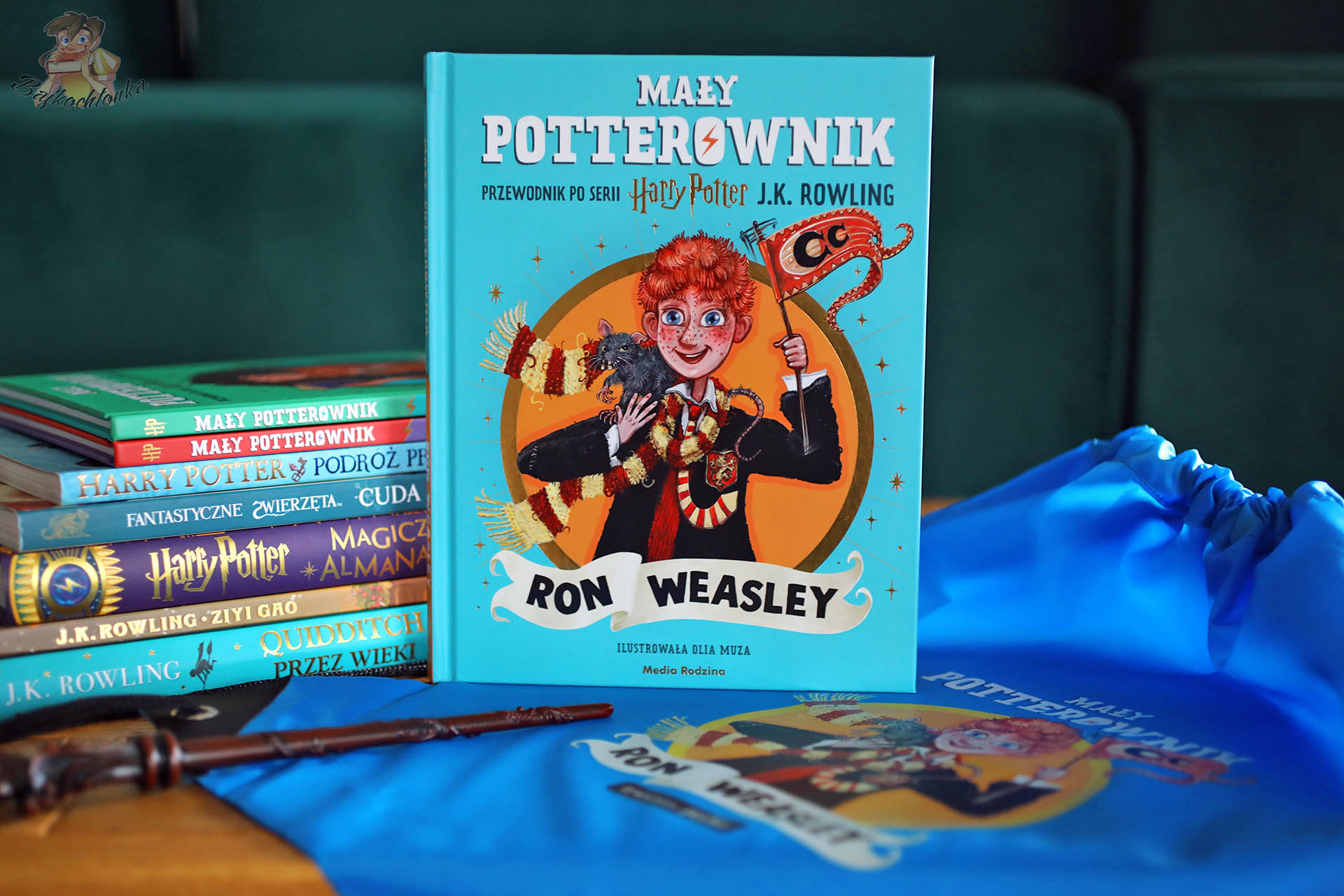 „Mały potterownik: Ron Weasley” – okładka na tle niebieskiego worka, w kadrze różdżka i książki z serii