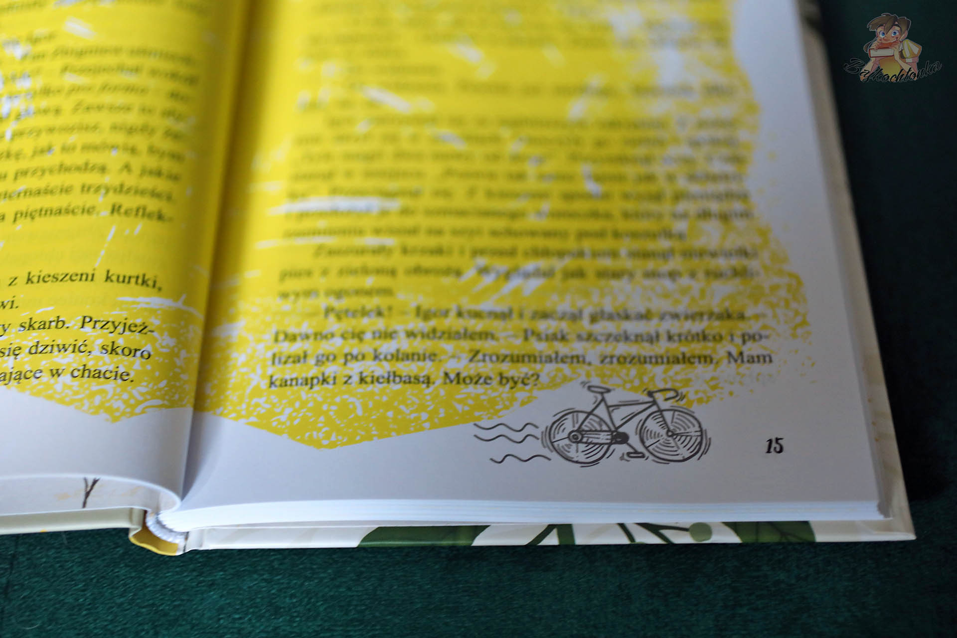 Zbliżenie składu „Szczygłów”: żółte tło i mała ilustracja roweru przy numeracji strony.