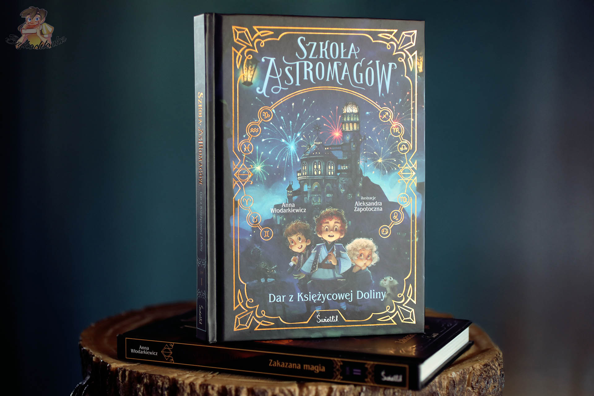 Szkoła Astromagów. Dar z Księżycowej Doliny – okładka tom 1 na stosie z tomem 2 Zakazana magia