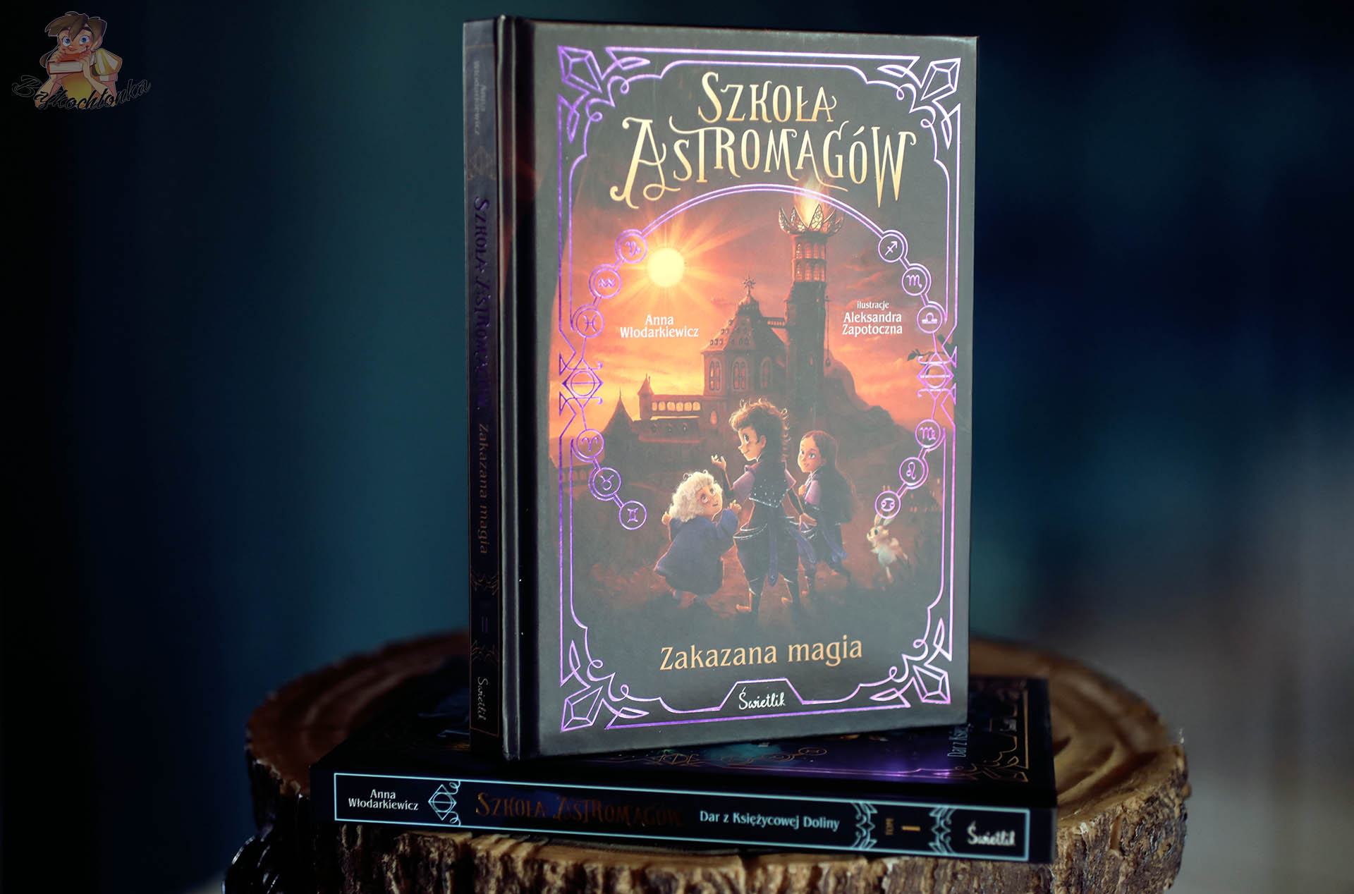 Szkoła Astromagów. Zakazana magia – okładka tomu 2 na stosie z tomem 1 Dar z Ksiezycowej Doliny (aranżacja)