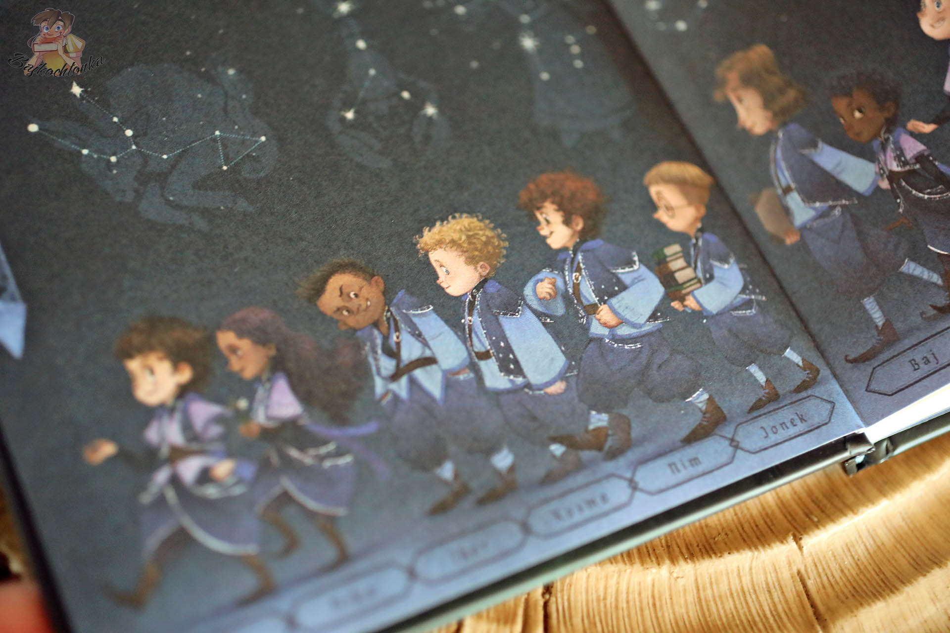 Szkoła Astromagów – wyklejka z uczniami pierwszego roku i zarysami gwiazdozbiorów