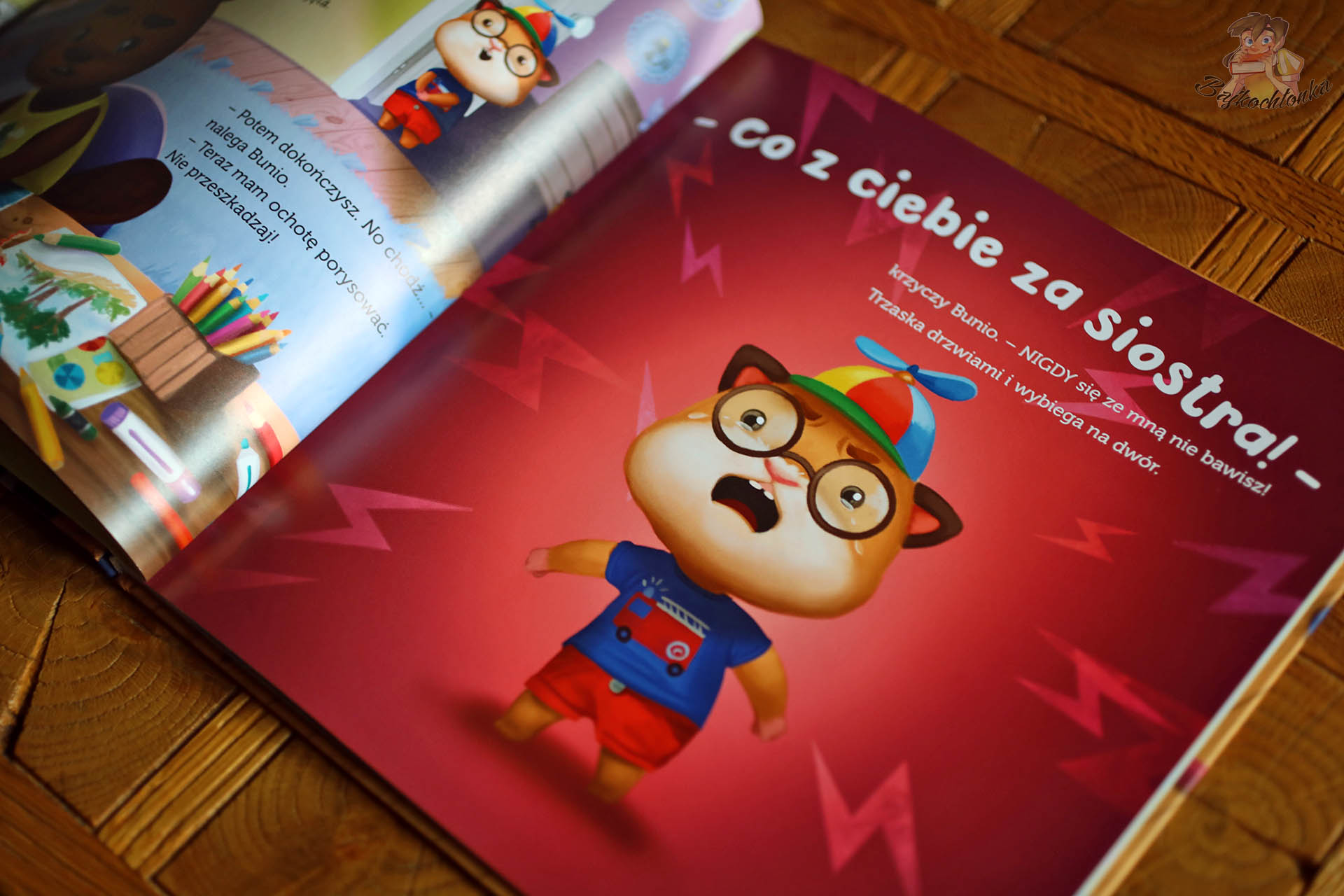 Rozkładówka z „Bunio chce się bawić” pokazująca silne emocje i złość Bunia na czerwonym tle – historia o radzeniu sobie z odrzuceniem.