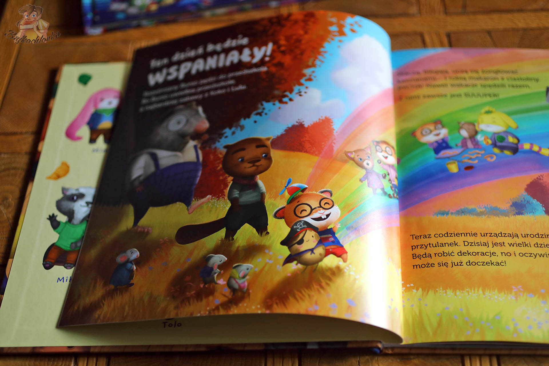 Strona z książki „Bunio chce się bawić” – bohaterowie spacerują po łące, scena ciepła i wspierająca, opowieść o przyjaźni i akceptacji.