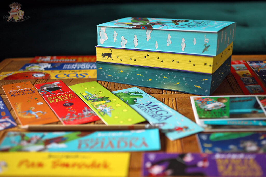 Kolekcja książek Davida Walliamsa w limitowanej serii z barwionymi brzegami obok zakładek i materiałów promocyjnych