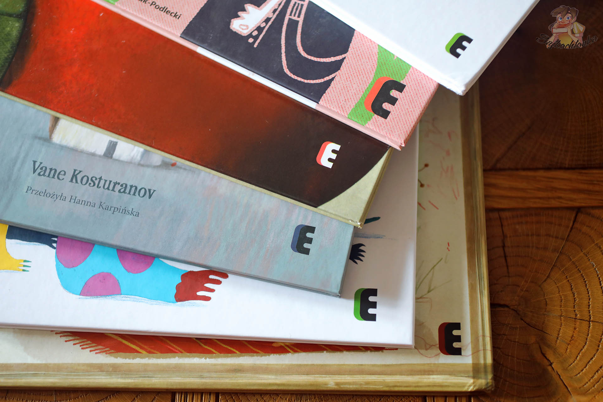 Zbliżenie grzbietów książek dla dzieci – nowości Wydawnictwa Ezop z widocznym logo „E”