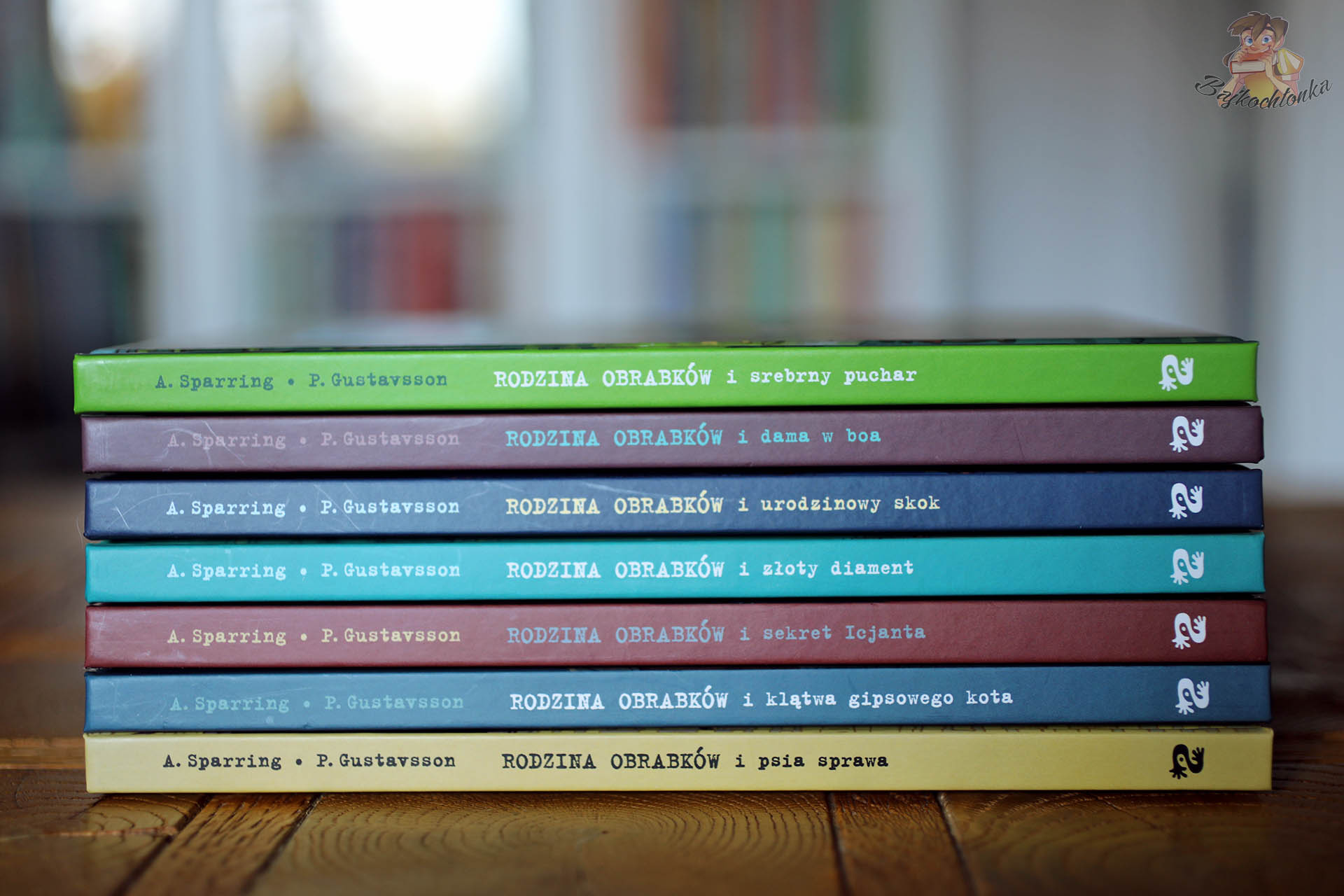 Stos tomów serii „Rodzina Obrabków” – grzbiety książek Zakamarki ułożone jeden na drugim