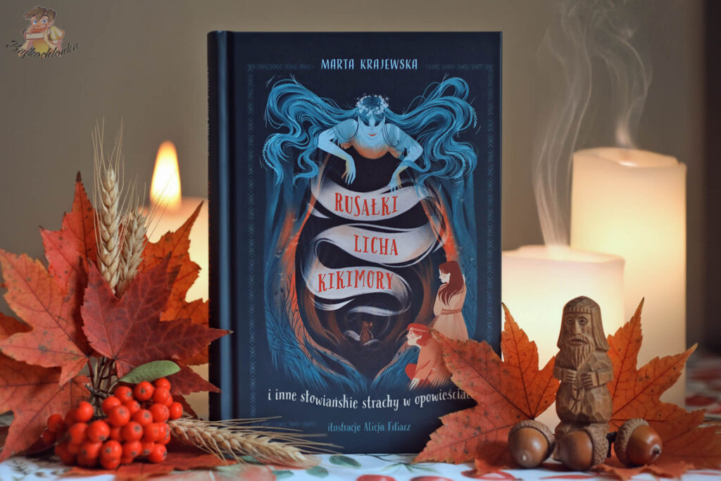 Okładka książki „Rusałki, licha, kikimory…” Marty Krajewskiej na tle świec i jesiennych liści – zdjęcie do recenzji.