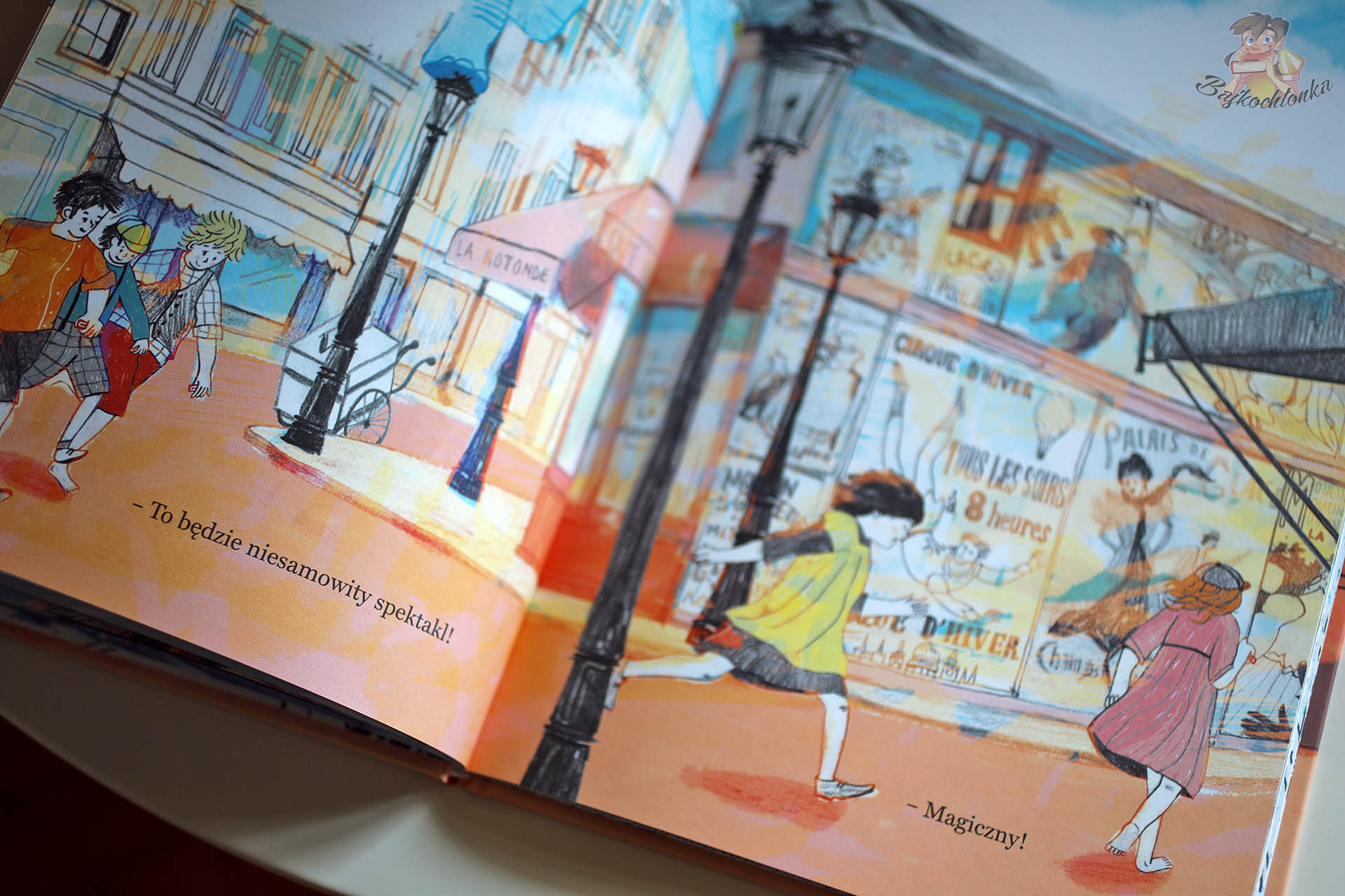 Widowisko – dzieci biegną ulicą Paryża obok plakatów cyrku | energia i magia codzienności