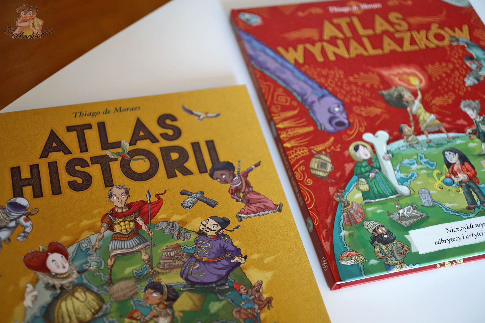 Okładki Atlasu wynalazków i Atlasu historii Thiago de Moraesa leżące obok siebie