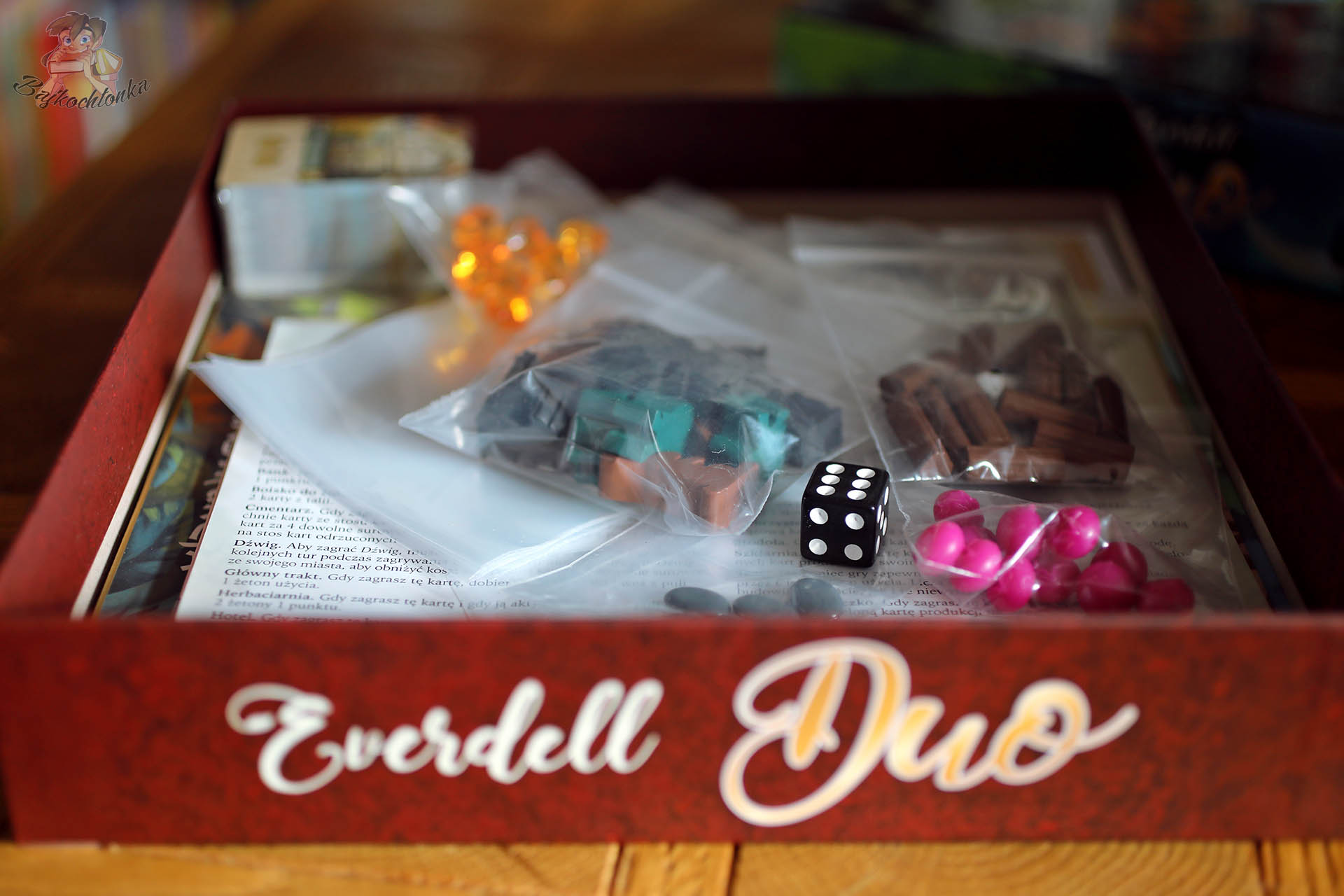 Komponenty Everdell Duo w pudełku – robotnicy, zasoby i kostka przed pierwszą grą