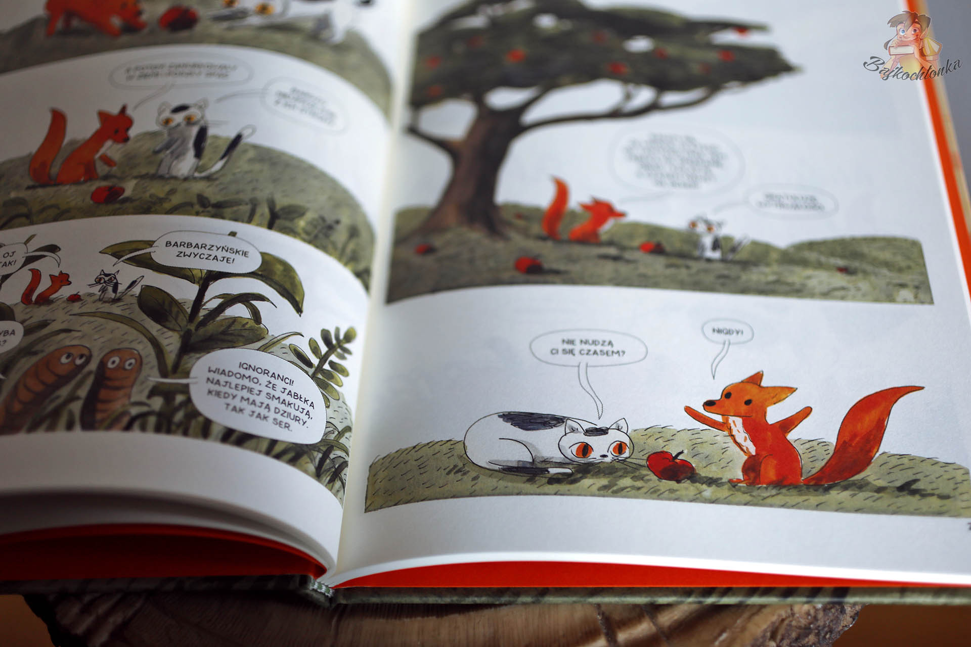 komiksowa rozkładówka z książki Kocina. Zapiski z Doliny Malutki Lisek i Kocina rozmawiają pod jabłonią, wokół spadają jabłka