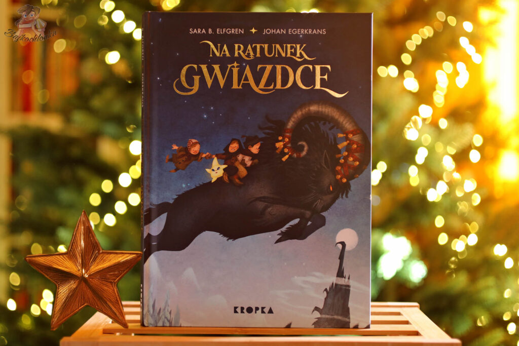 Na ratunek Gwiazdce – okładka świątecznej książki Sary B. Elfgren, wydawnictwo Kropka, na tle choinki