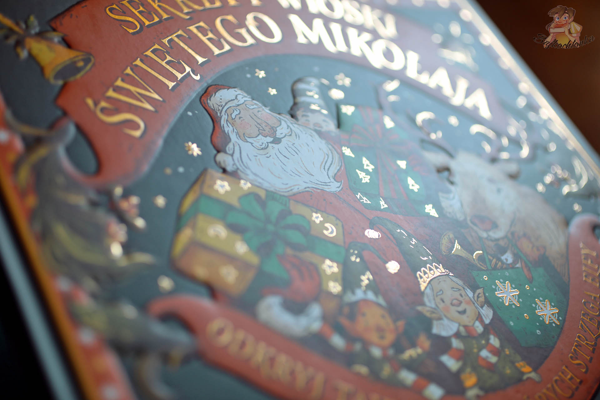 Zbliżenie na złote uszlachetnienia i tłoczenia na okładce książki Sekrety wioski Świętego Mikołaja