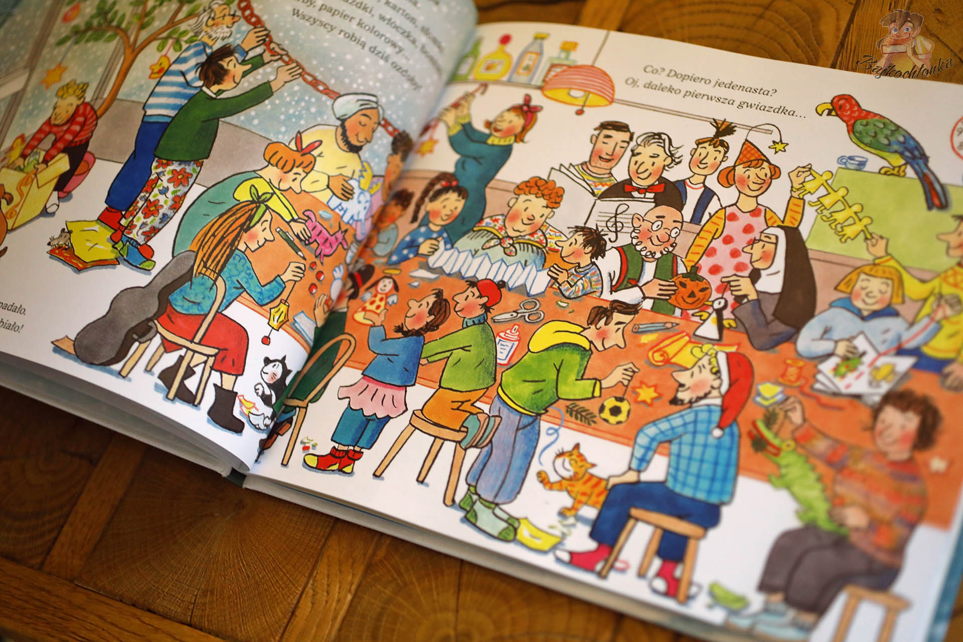 Dzieci i dorośli przygotowują świąteczne dekoracje w kawiarni przy jeziorze, ilustracja z książki Święta na ulicy Czereśniowej