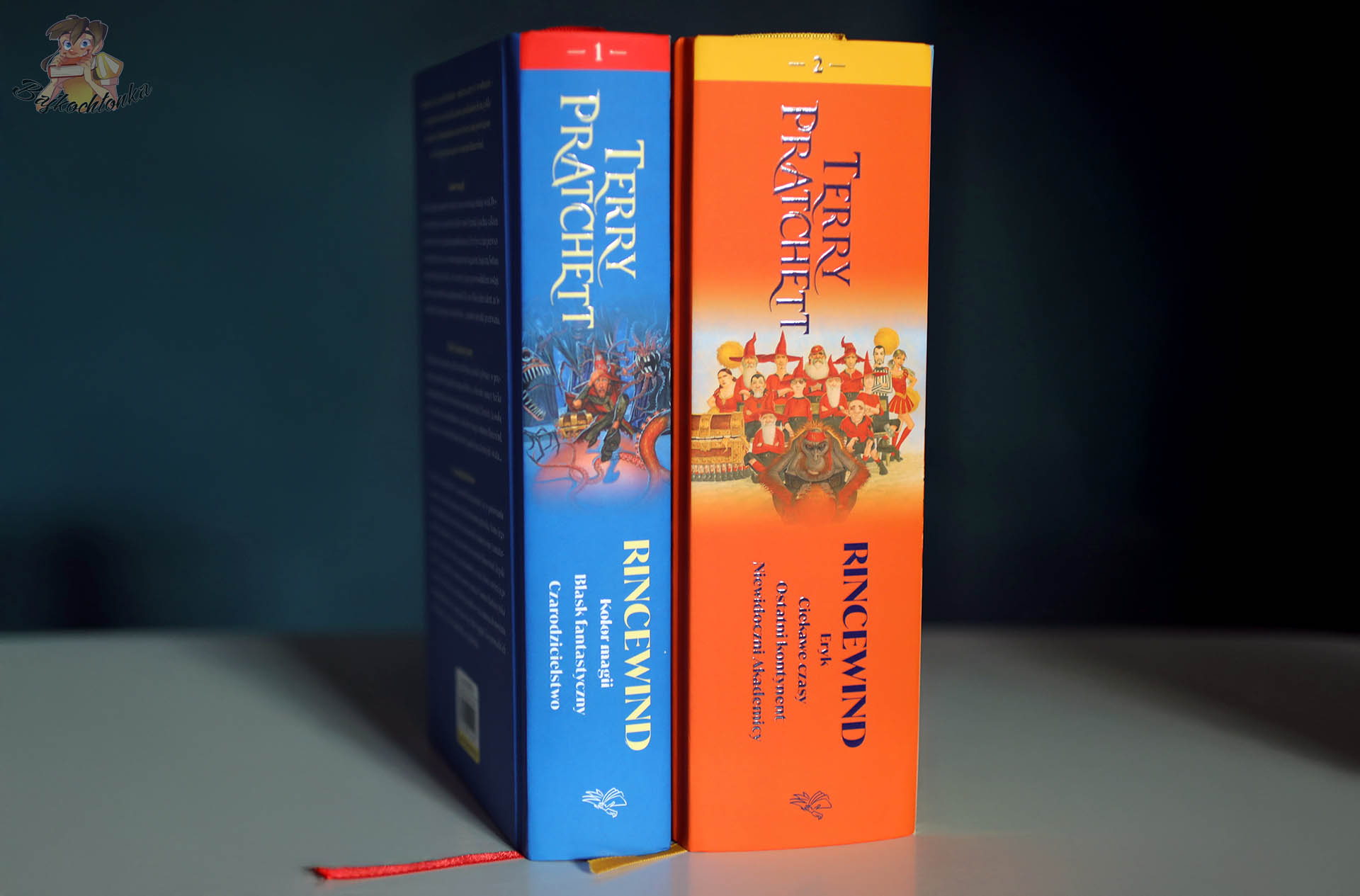 Grzbiety omnibusów „Rincewind tom 1” i „Rincewind tom 2” Terry’ego Pratchetta ustawionych pionowo