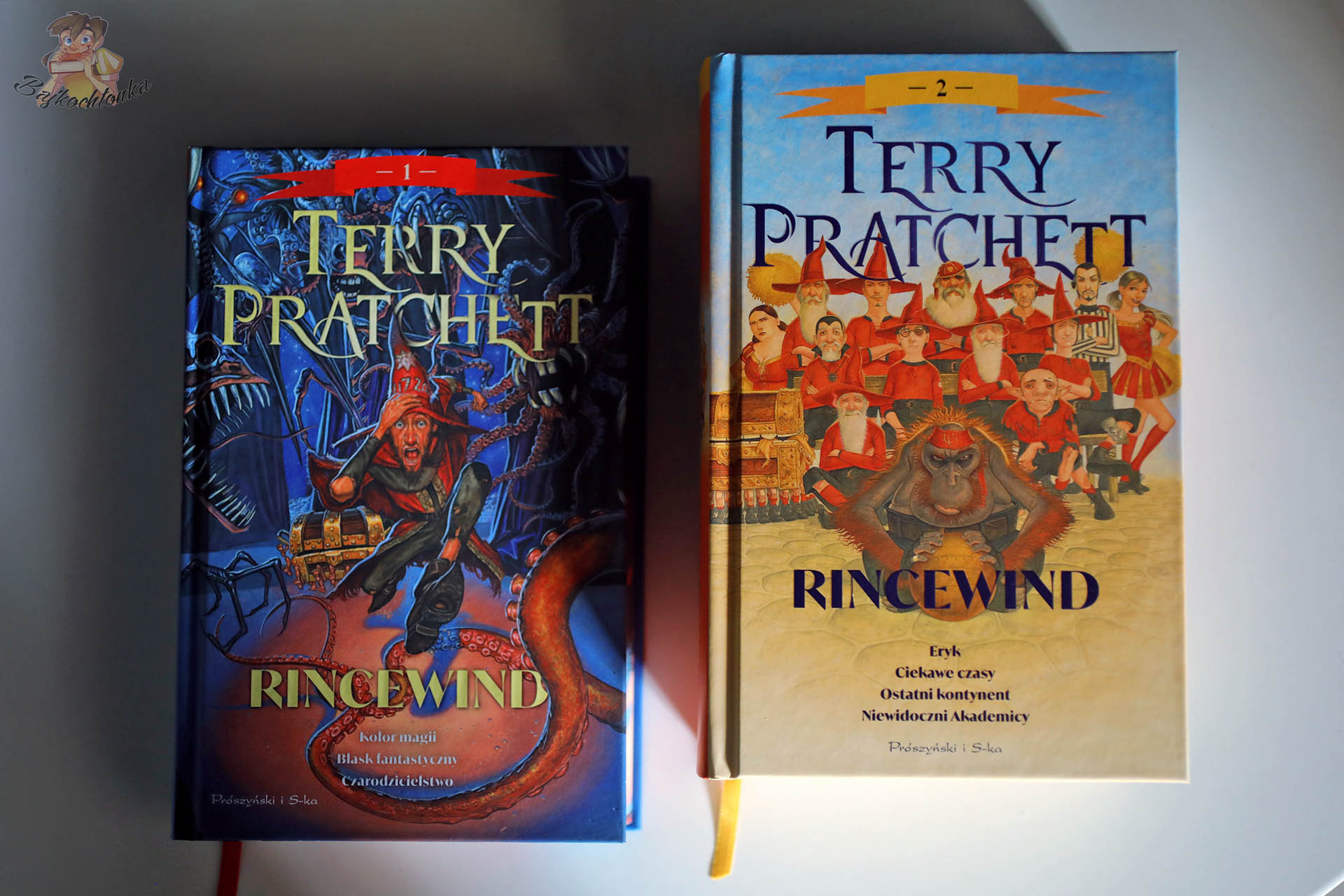 Okładki omnibusów „Rincewind tom 1” i „Rincewind tom 2” Terry’ego Pratchetta obok siebie