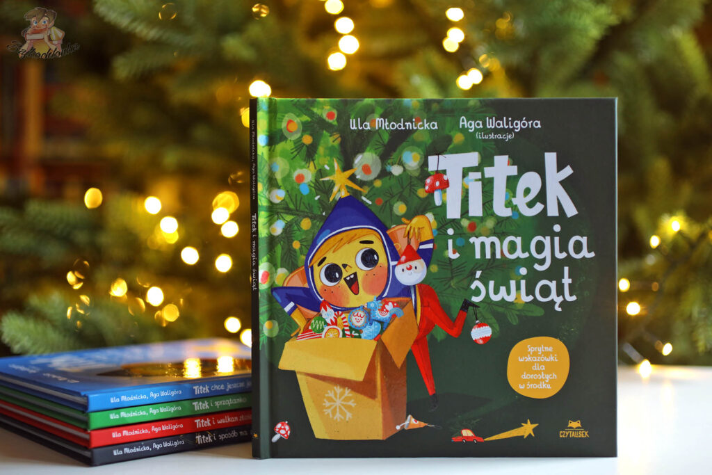 Okładka książki Titek i magia świąt na tle choinki, obok pozostałych tomów z serii Titek