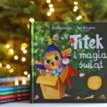 Okładka książki Titek i magia świąt na tle choinki, obok pozostałych tomów z serii Titek