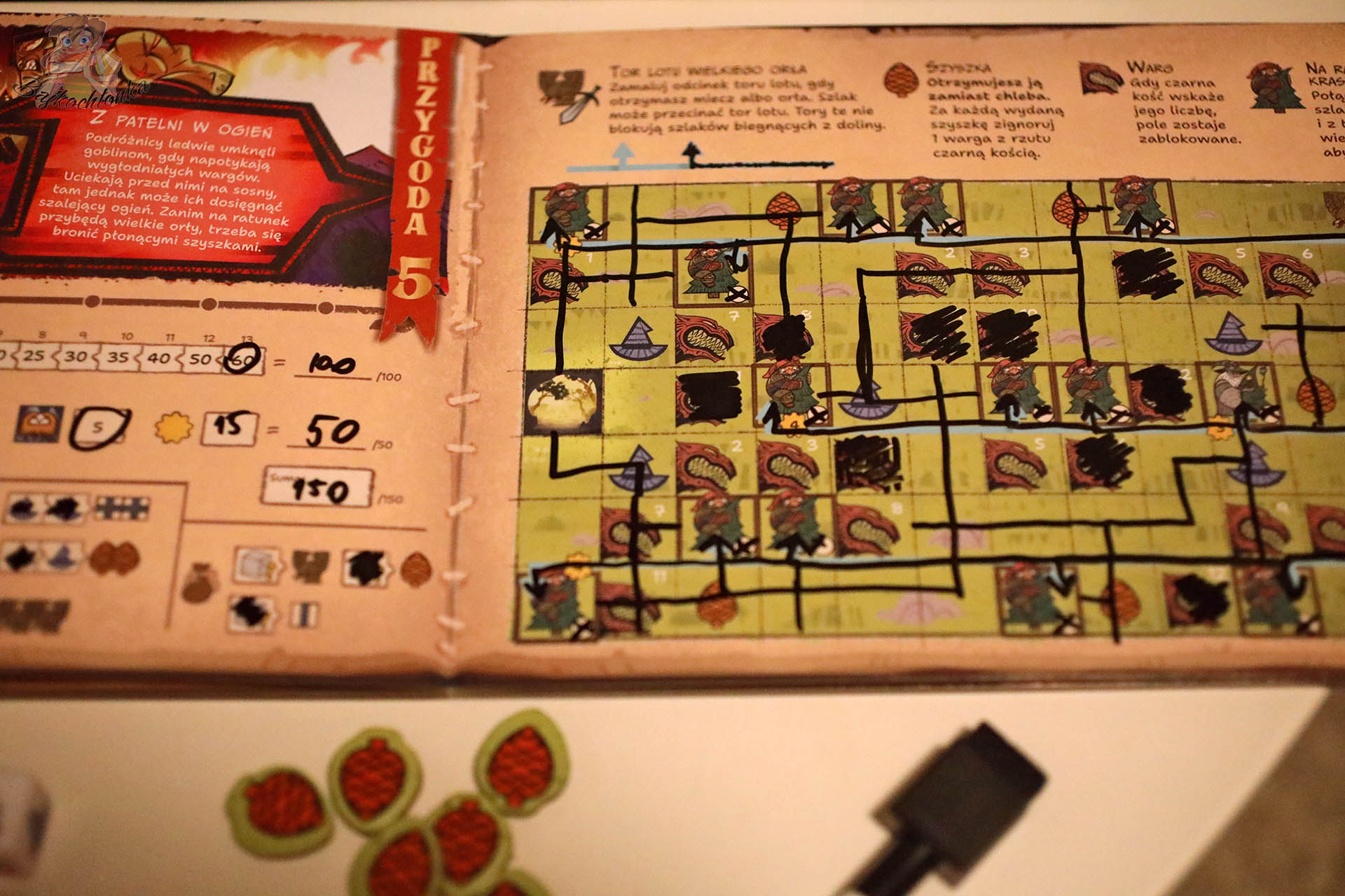 Plansza książkowa z Przygodą 5 „Z patelni w ogień” w grze „Hobbit: Tam i z powrotem” z narysowanymi ścieżkami i wynikami