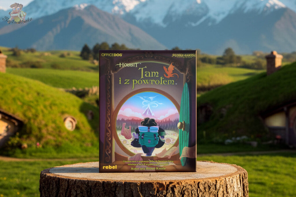 Pudełko gry planszowej „Hobbit: Tam i z powrotem” ustawione w plenerze przypominającym Shire ze Śródziemia