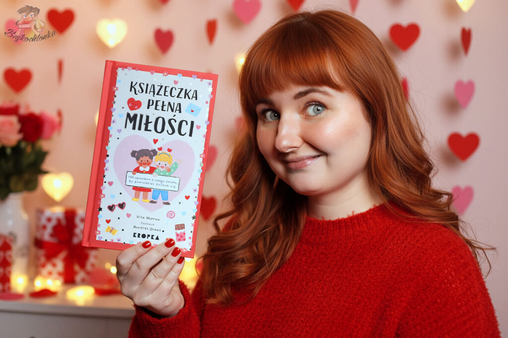 Książeczka pełna miłości – Bajkochłonka trzyma książkę na tle serduszek