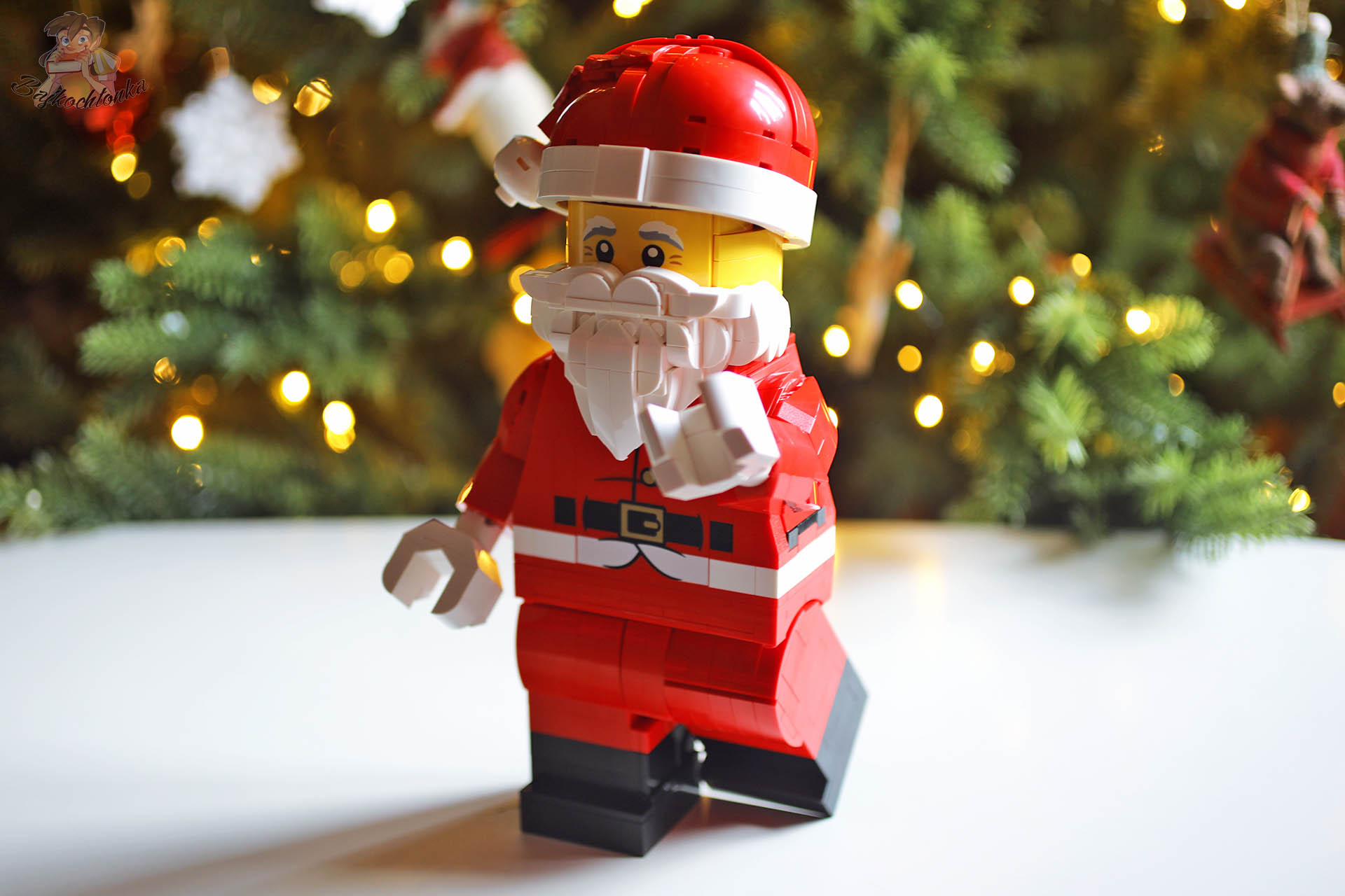 LEGO 40820 Powiększona minifigurka Świętego Mikołaja w czerwonym stroju pozuje przed choinką