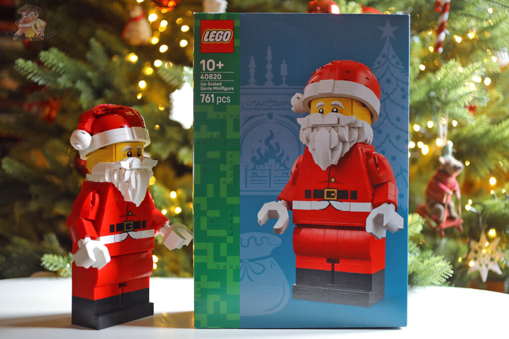 Zbudowana powiększona minifigurka Świętego Mikołaja LEGO 40820 stojąca obok pudełka zestawu