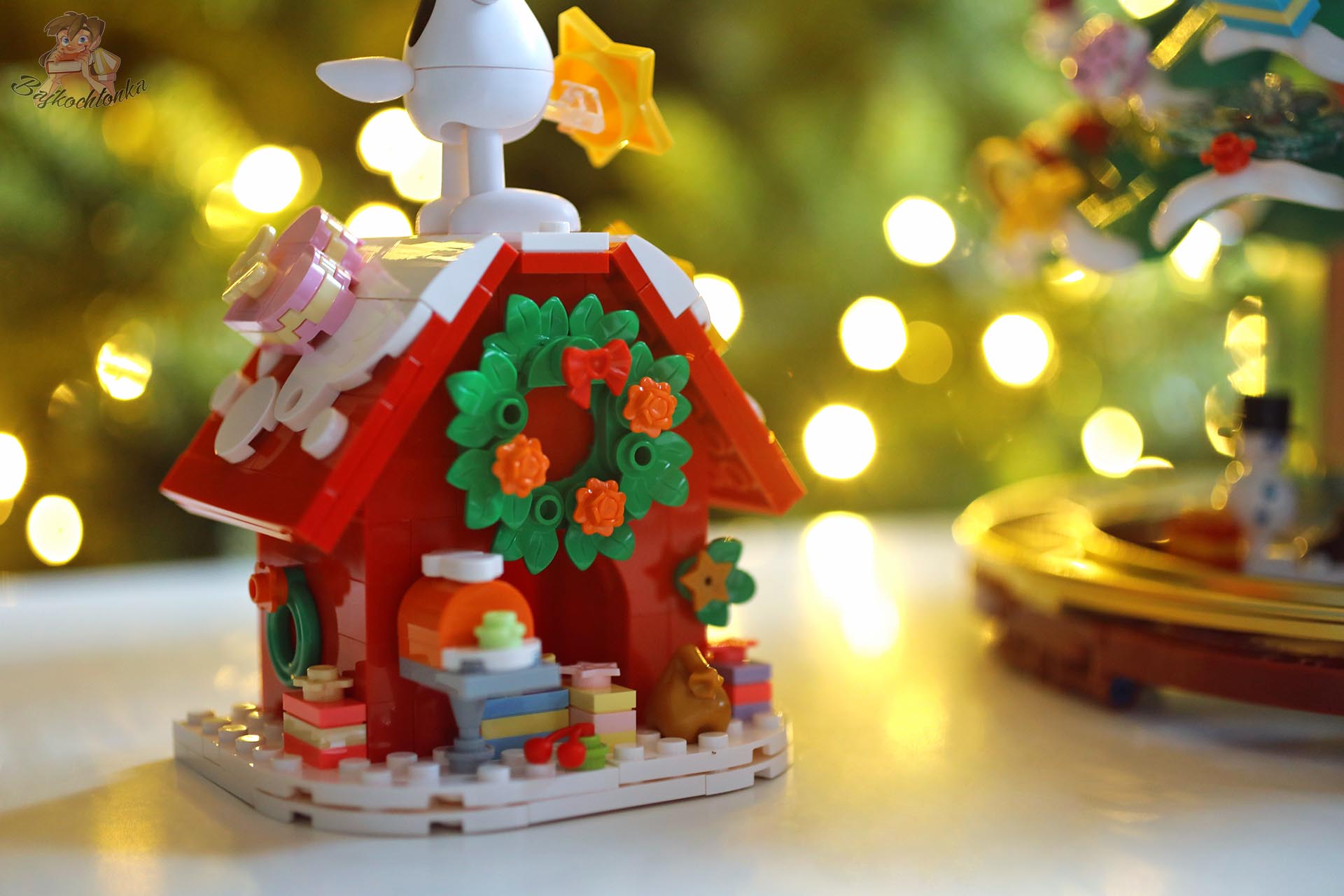 Domek Snoopy’ego ozdobiony świątecznym wieńcem i prezentami, element zestawu Pantasy Peanuts Christmas Tree 86909.
