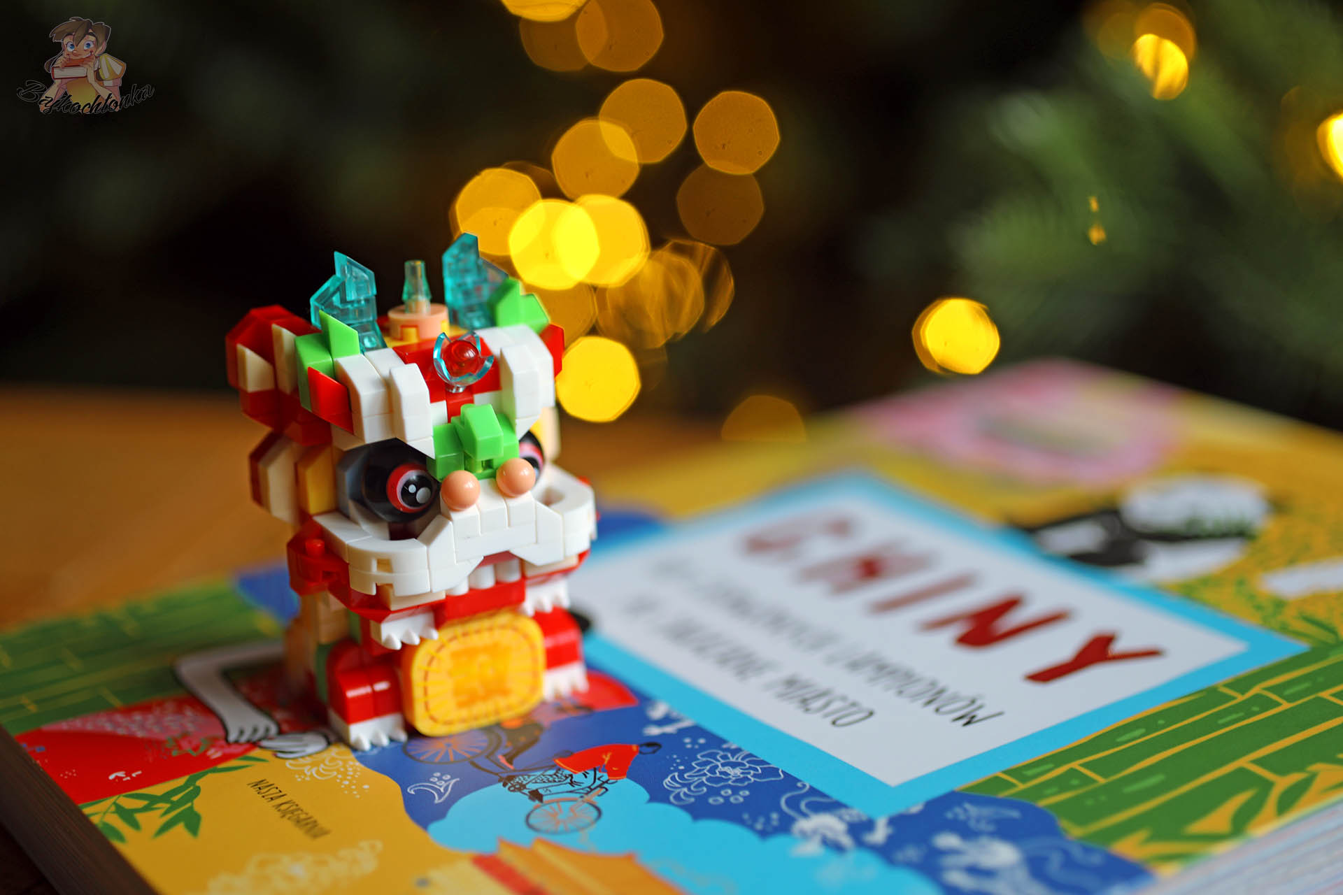 Figurka smoka i książka „Chiny. Od czerwonych lampionów po Zakazane Miasto” – symbolika Chińskiego Nowego Roku
