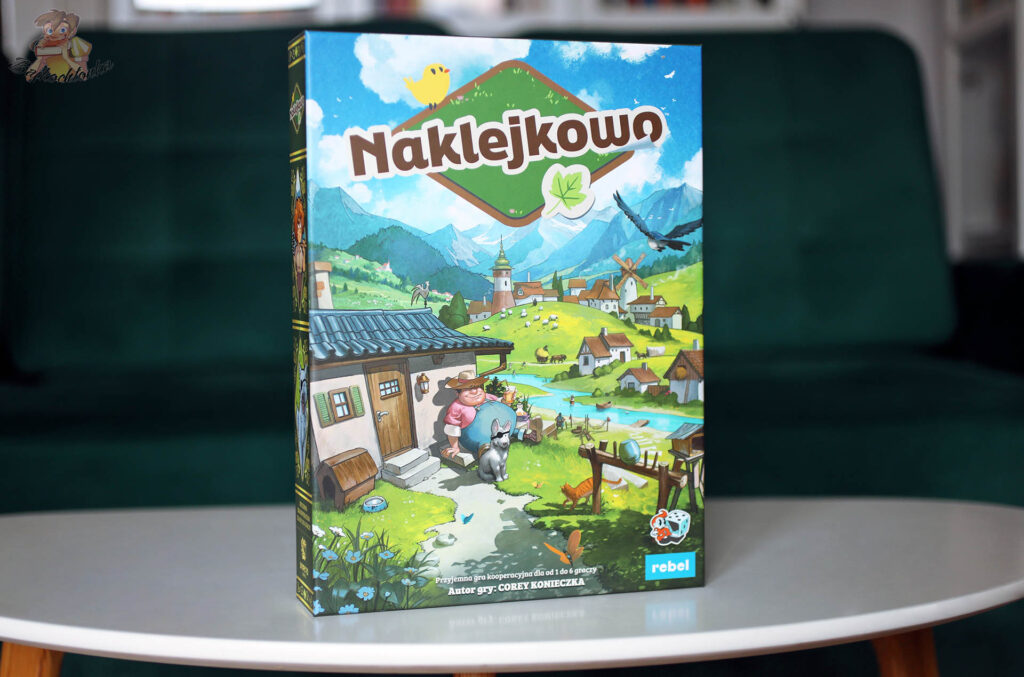 Okładka gry planszowej Naklejkowo wydawnictwa Rebel – kooperacyjne budowanie miasteczka