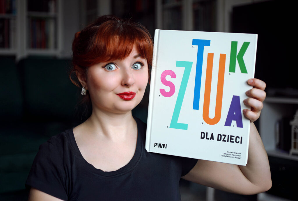 Recenzentka trzyma książkę „Sztuka dla dzieci” PWN – zdjęcie do artykułu na blogu Bajkochłonka