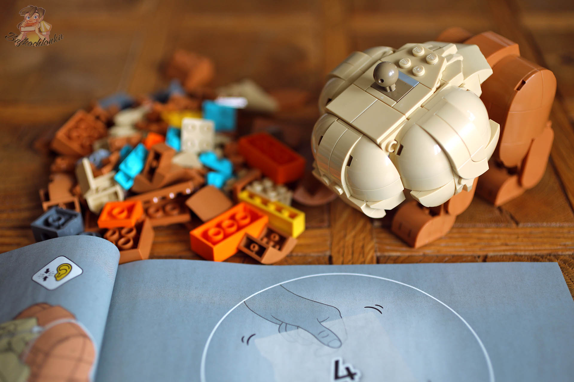 Elementy zestawu LEGO Pokémon Eevee podczas budowy oraz otwarta instrukcja składania