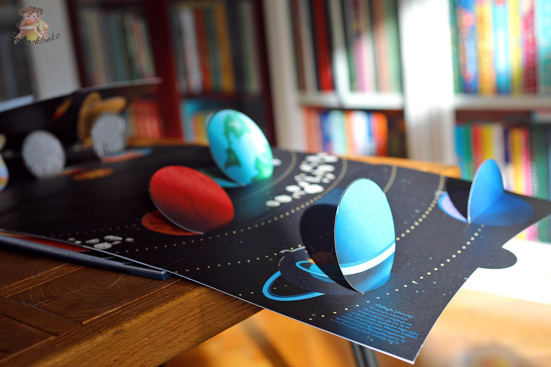 Trójwymiarowe planety na rozkładówce książki Papierowy świat Kosmos, książka z okienkami i elementami przestrzennymi o Układzie Słonecznym