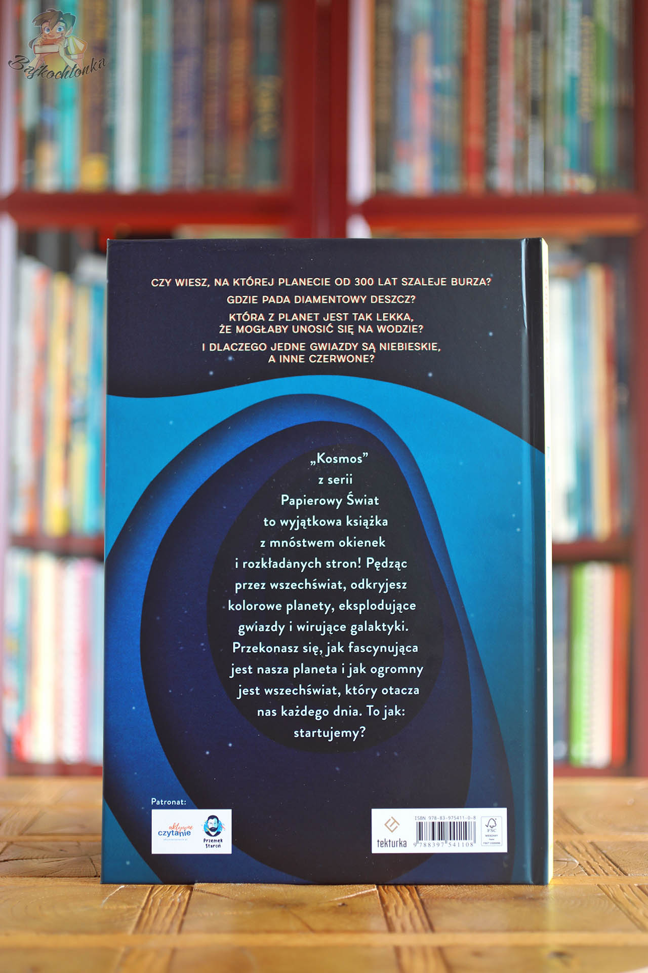Tył okładki książki Papierowy świat Kosmos z opisem treści i pytaniami o planety, edukacyjna książka popularnonaukowa dla dzieci