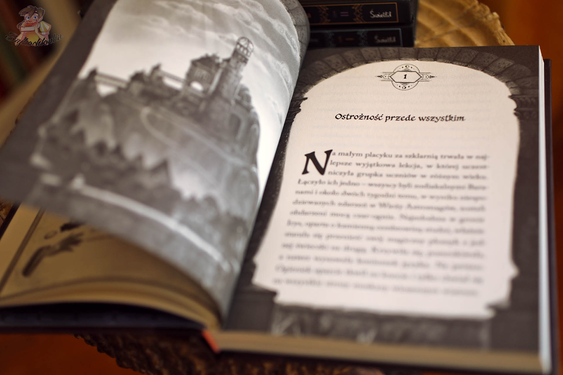 początek rozdziału książki Szkoła Astromagów Tajniki Ognia z dekoracyjną ramką i ilustracją szkoły magii