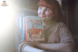 czytelniczka trzyma książki Zuza Wróbel na tropie – seria detektywistyczna dla dzieci