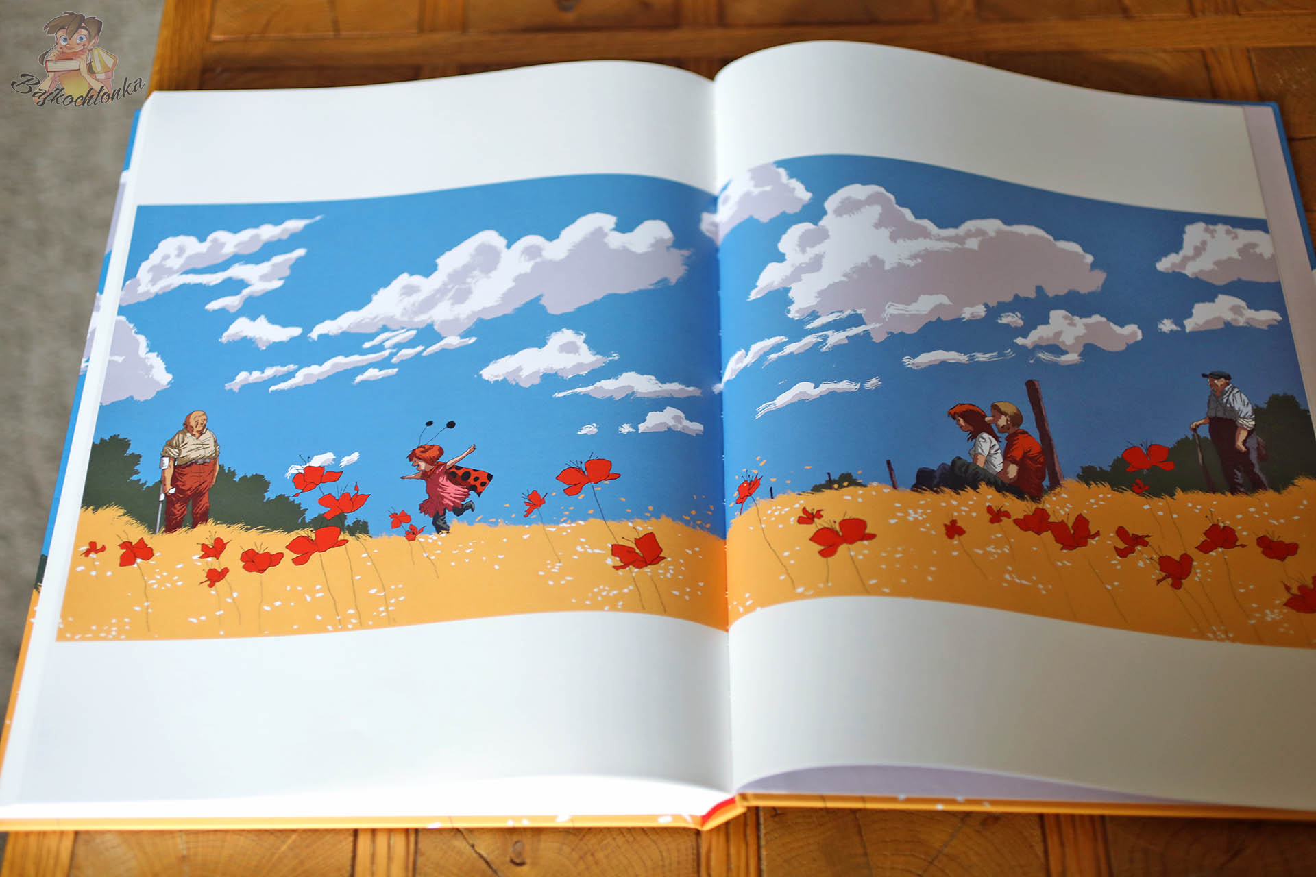 Rozkładówka komiksu Codzienna walka Manu Larceneta z polem maków, bohaterami i błękitnym niebem