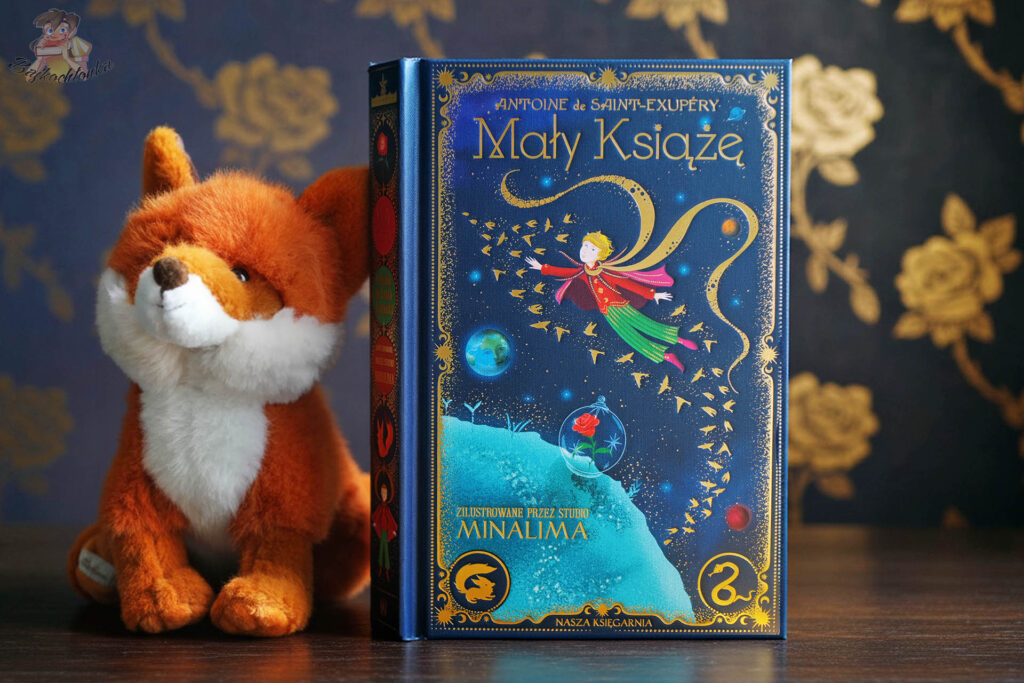 książka Mały Książę MinaLima ustawiona obok pluszowego liska na ciemnym tle