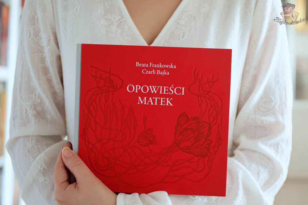 kobieta trzyma książkę Opowieści matek – wyjątkowa książka dla przyszłych i obecnych mam