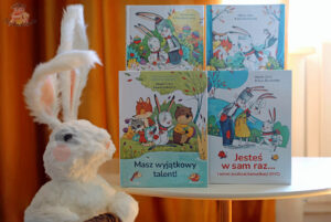 Książki z serii o Pomponie autorstwa Oliviera Clerca i Gai Bordicchii z pluszowym królikiem obok