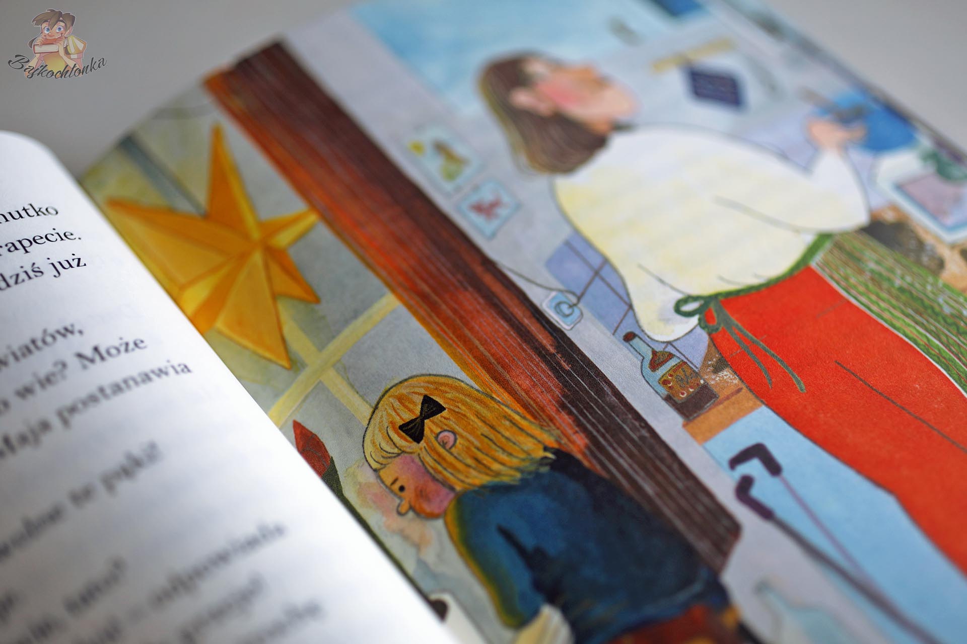 Świąteczna ilustracja z książki Tata i ja pokazująca Maję przy stole i bożonarodzeniowe dekoracje