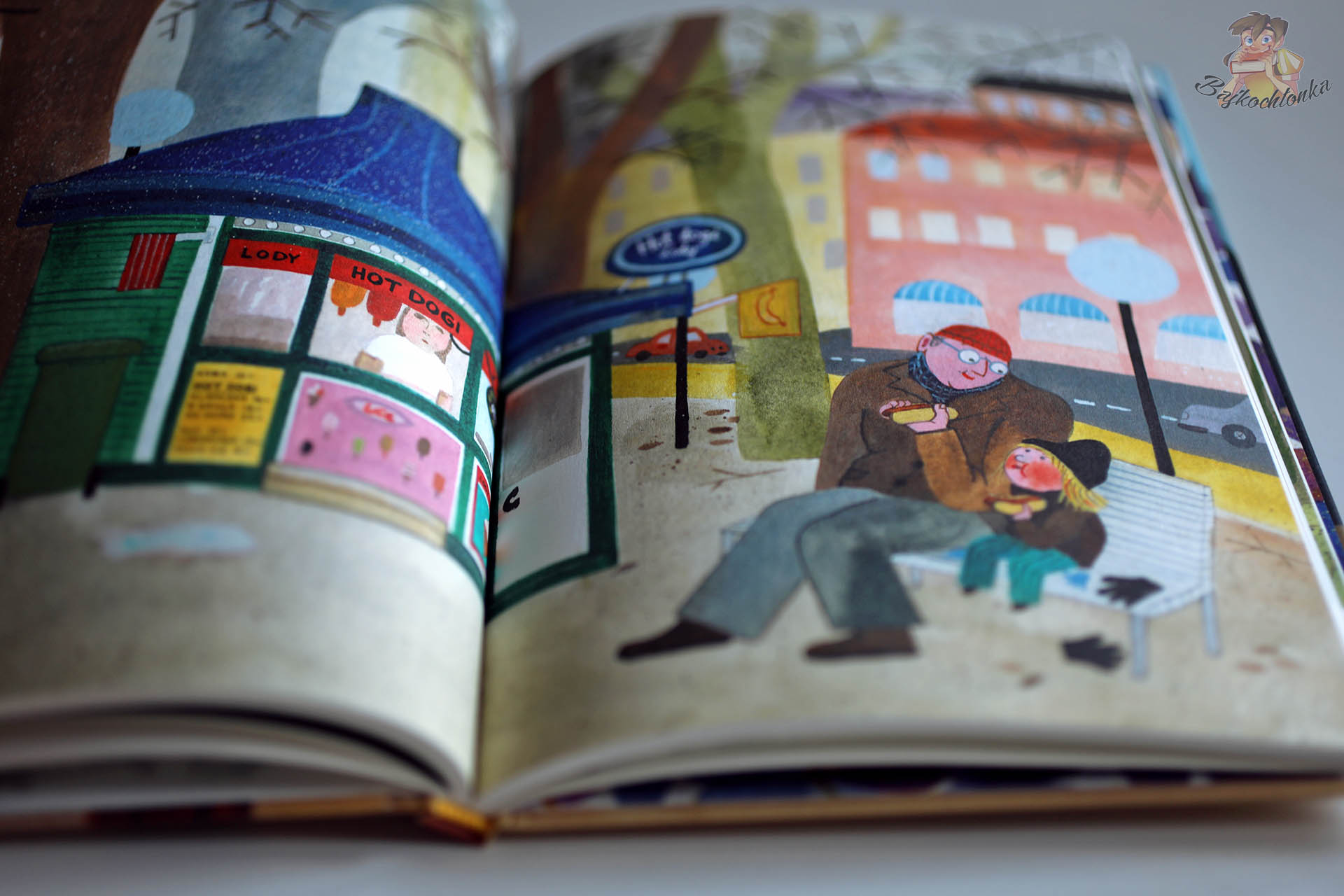 Ilustracja z książki Tata i ja pokazująca Maję i tatę jedzących hot dogi w mieście