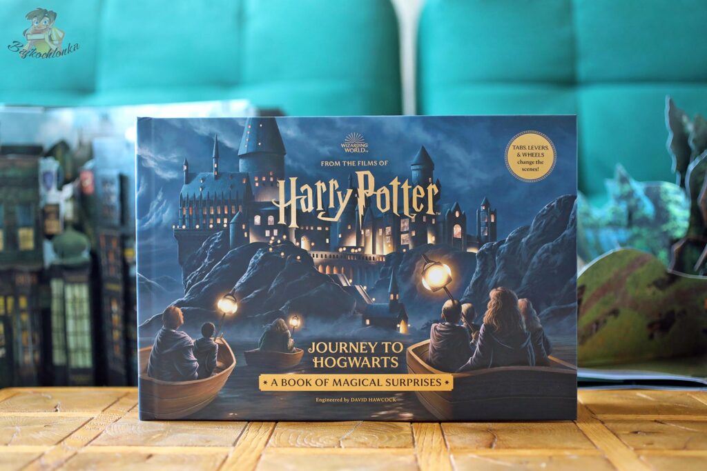 Okładka książki Harry Potter’s Journey to Hogwarts. A Book of Magical Surprises od Insight Editions z łodziami płynącymi do Hogwartu