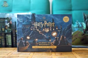 Okładka książki Harry Potter’s Journey to Hogwarts. A Book of Magical Surprises od Insight Editions z łodziami płynącymi do Hogwartu