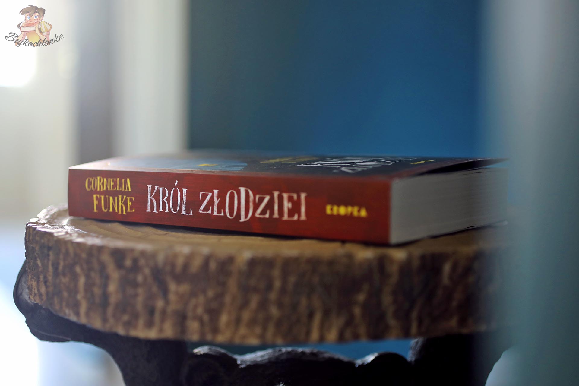 Grzbiet książki Król złodziei Cornelii Funke na drewnianym stoliku