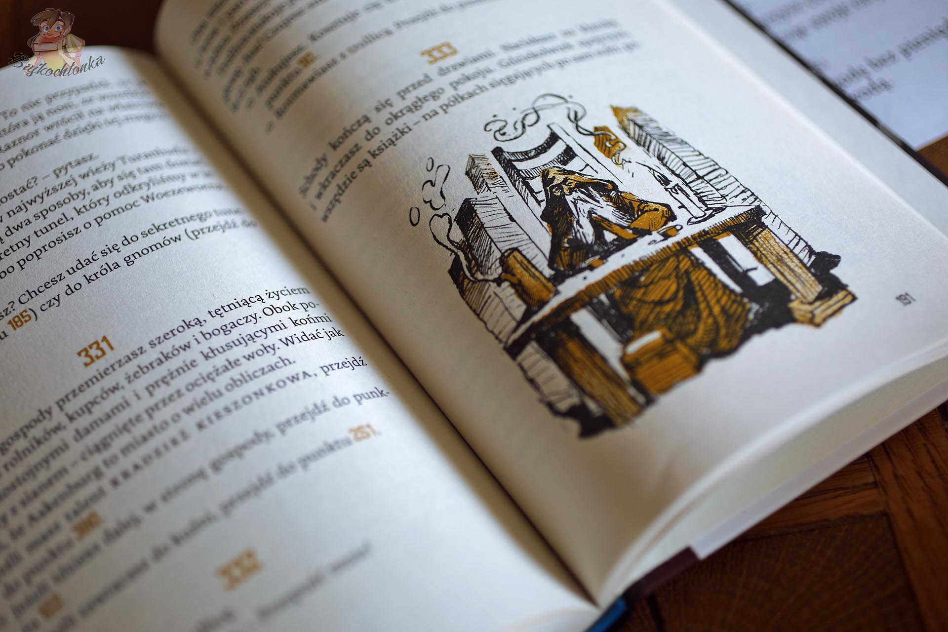 Rozkładówka książki Książka do grania. Wrona Cienia Marcela Groenewegena z numerowanymi paragrafami i ilustracją miasta, pokazująca interaktywną konstrukcję książki paragrafowej.