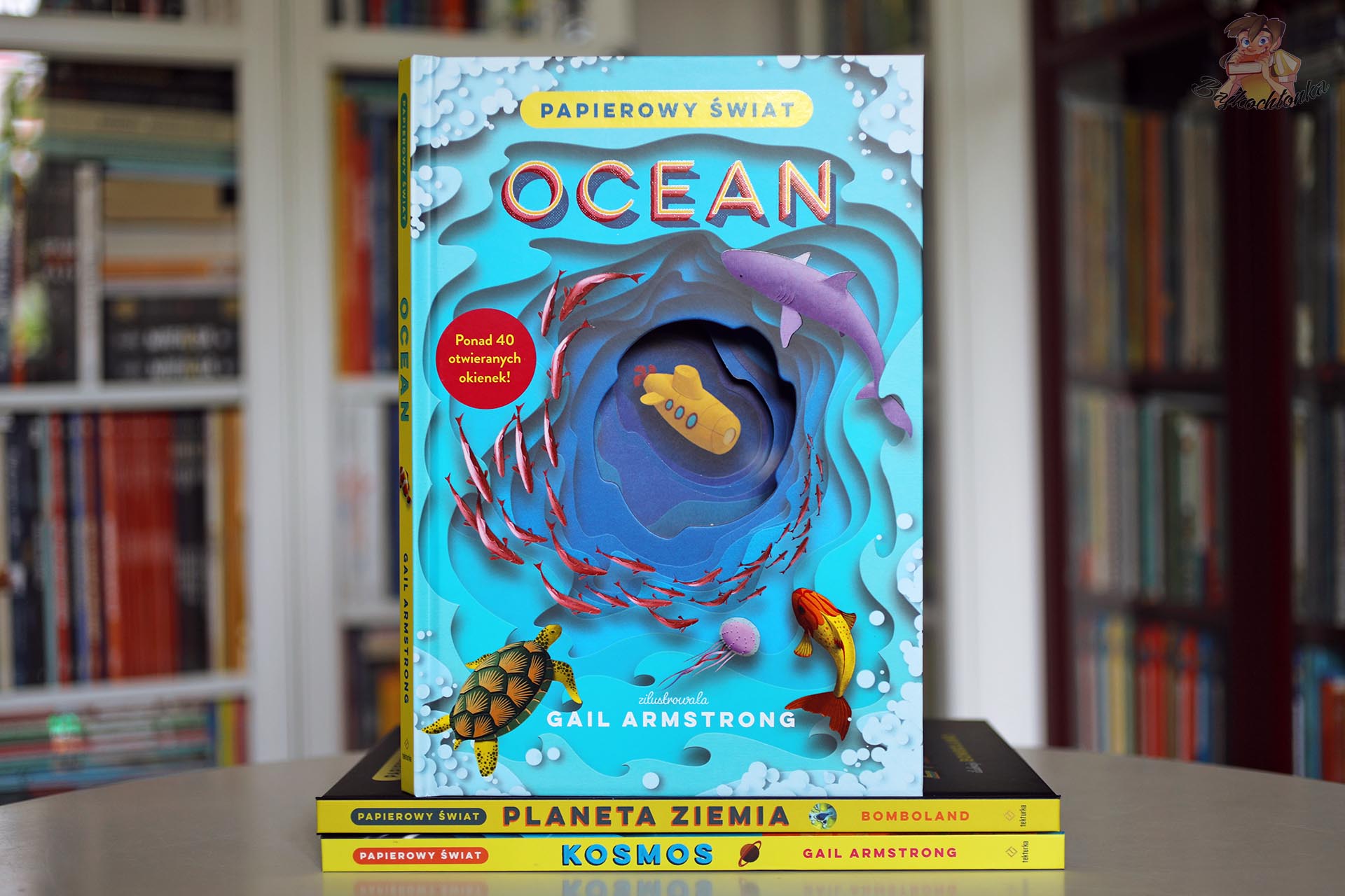 Okładka książki Ocean. Papierowy Świat Gail Armstrong z podwodną sceną, rekinem, żółwiem i papierową głębią.