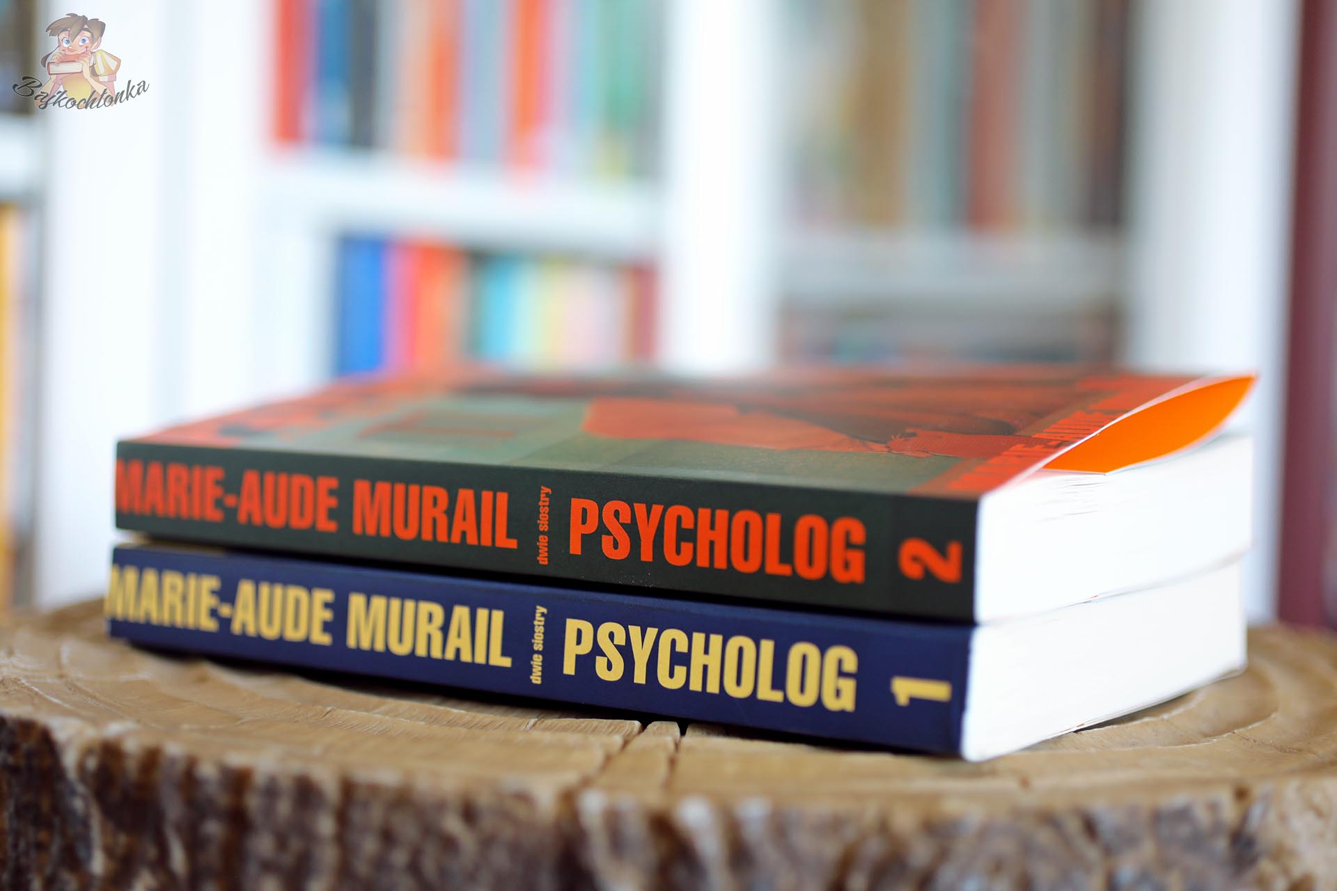 Grzbiety książek Psycholog 1 i Psycholog 2 Marie-Aude Murail ułożonych jeden na drugim na drewnianym stoliku.