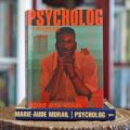 Okładka książki Psycholog. Tom 2. Coś o sobie wiem Marie-Aude Murail ustawiona na pierwszym tomie serii, na tle domowej biblioteczki.Okładka książki Psycholog. Tom 2. Coś o sobie wiem Marie-Aude Murail ustawiona na pierwszym tomie serii, na tle domowej biblioteczki.