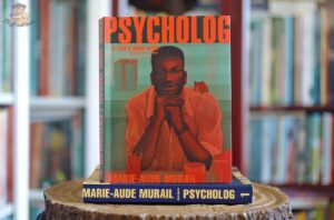 Okładka książki Psycholog. Tom 2. Coś o sobie wiem Marie-Aude Murail ustawiona na pierwszym tomie serii, na tle domowej biblioteczki.Okładka książki Psycholog. Tom 2. Coś o sobie wiem Marie-Aude Murail ustawiona na pierwszym tomie serii, na tle domowej biblioteczki.